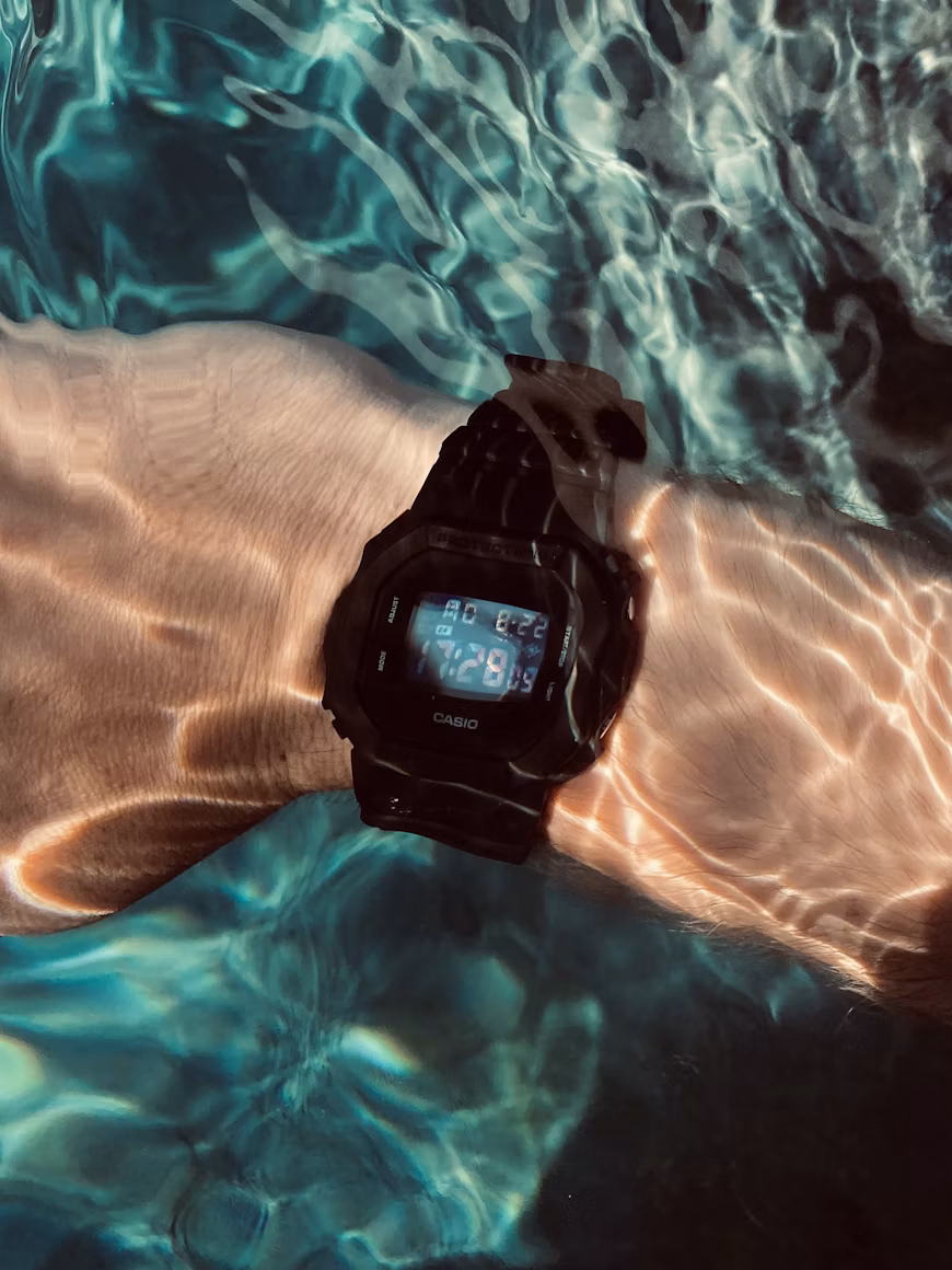 G-Shock on a wrist in sunlit water; editorial photograph, not a pictured listing